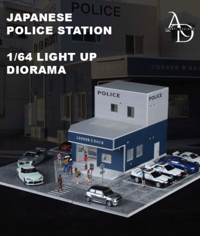 Model of a Japanese police station with cars and people in front, labeled 'Japanese Police Station 1/64 Light Up Diorama'.